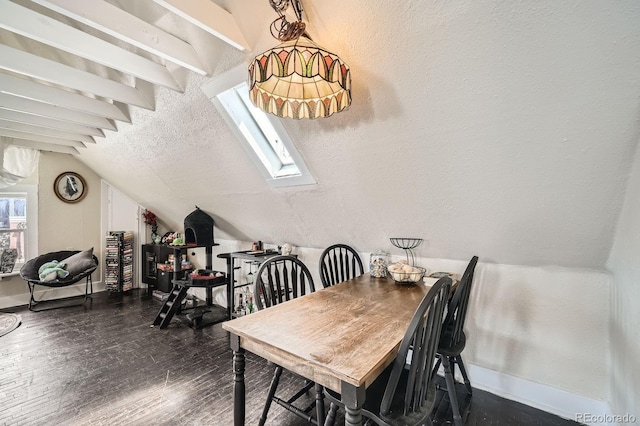 dining space with baseboards, vaulted ceiling with skylight, and dark wood-type flooring
