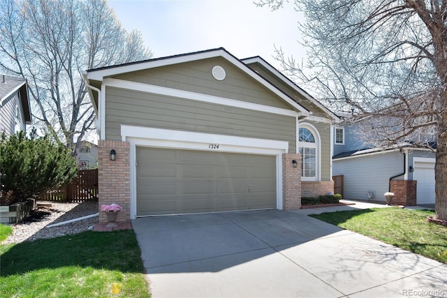 traditional home featuring concrete driveway, brick siding, fence, and a garage