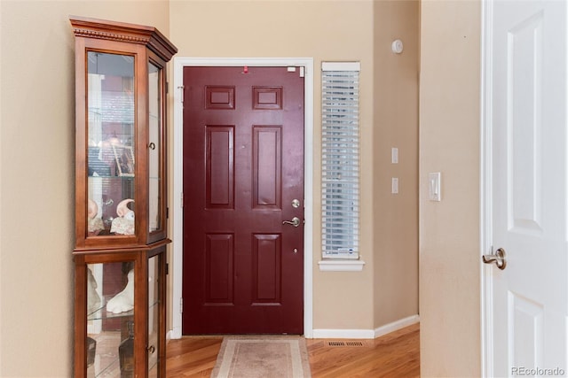 entryway with baseboards, visible vents, and light wood-type flooring