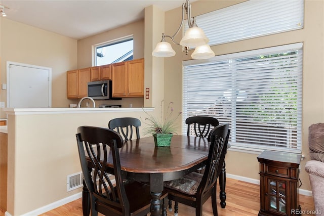 dining area featuring light wood-style floors and baseboards