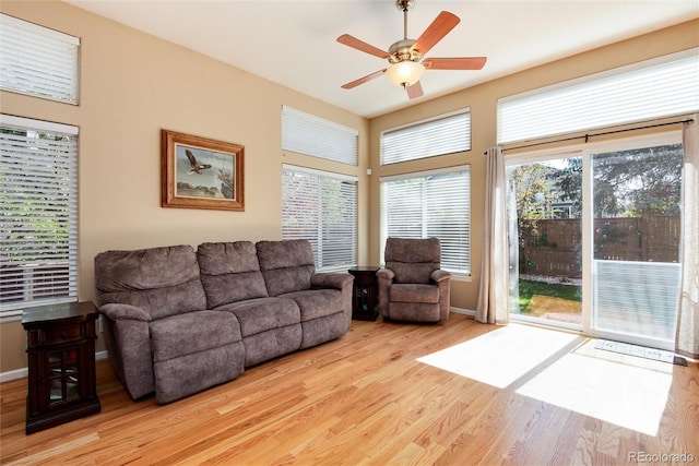 living room featuring baseboards, a ceiling fan, and wood finished floors