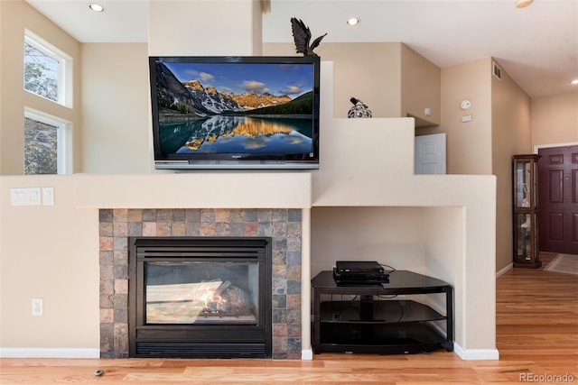interior details with recessed lighting, wood finished floors, and a tile fireplace