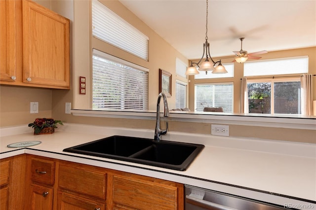 kitchen with ceiling fan, light countertops, a sink, dishwasher, and hanging light fixtures