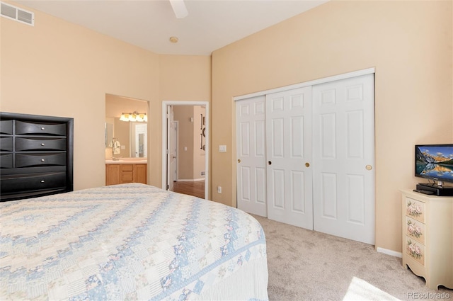 carpeted bedroom featuring visible vents, ceiling fan, a closet, and ensuite bathroom