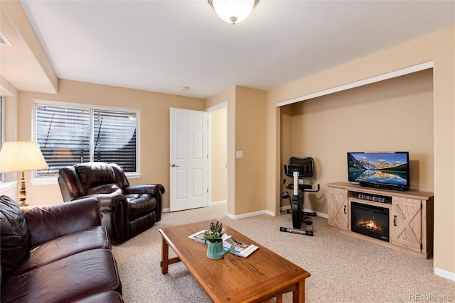 carpeted living room with baseboards and a glass covered fireplace