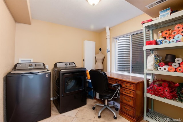 washroom with light tile patterned floors, laundry area, washing machine and dryer, and visible vents