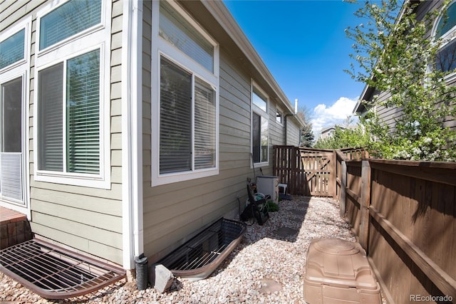 view of property exterior featuring fence and central AC unit