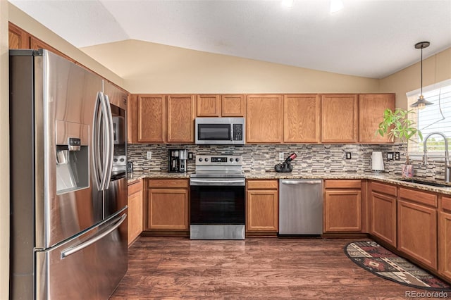 kitchen with lofted ceiling, decorative light fixtures, dark wood-type flooring, and stainless steel appliances