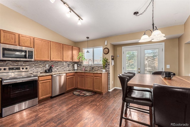 kitchen featuring hanging light fixtures, stainless steel appliances, a notable chandelier, sink, and dark hardwood / wood-style floors