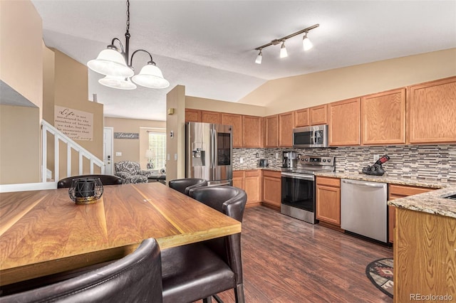 kitchen featuring decorative light fixtures, appliances with stainless steel finishes, dark hardwood / wood-style flooring, a notable chandelier, and lofted ceiling