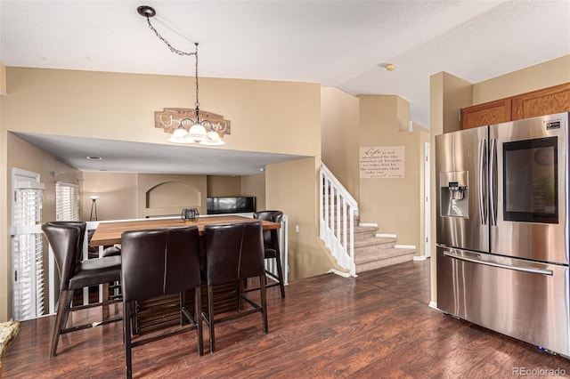 dining room featuring dark wood-type flooring, a notable chandelier, and vaulted ceiling