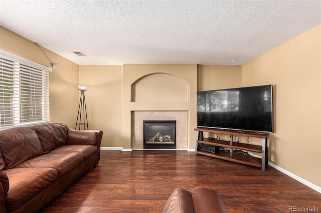 living room featuring a fireplace, dark hardwood / wood-style floors, and a textured ceiling