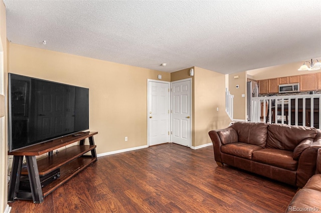 living room with dark hardwood / wood-style floors and a textured ceiling