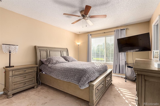 carpeted bedroom featuring a textured ceiling and ceiling fan