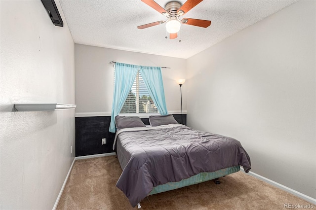 carpeted bedroom with a textured ceiling and ceiling fan