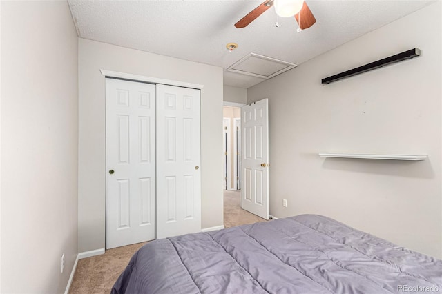 carpeted bedroom featuring a textured ceiling, ceiling fan, and a closet