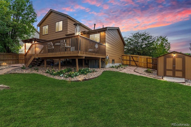 back house at dusk featuring a storage unit, a wooden deck, and a yard