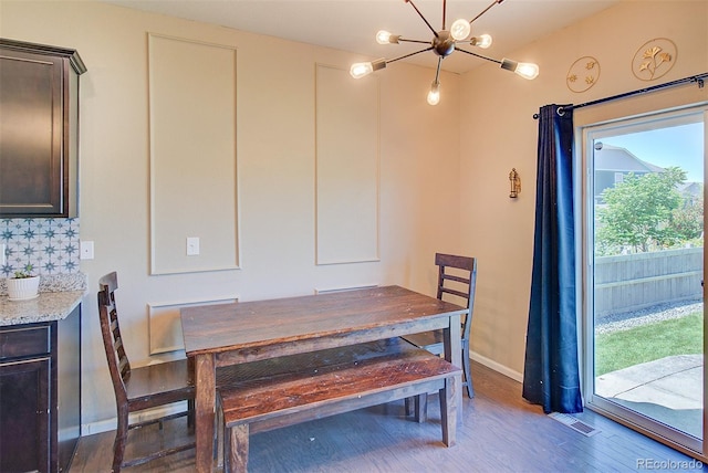 dining area featuring dark hardwood / wood-style flooring and a chandelier