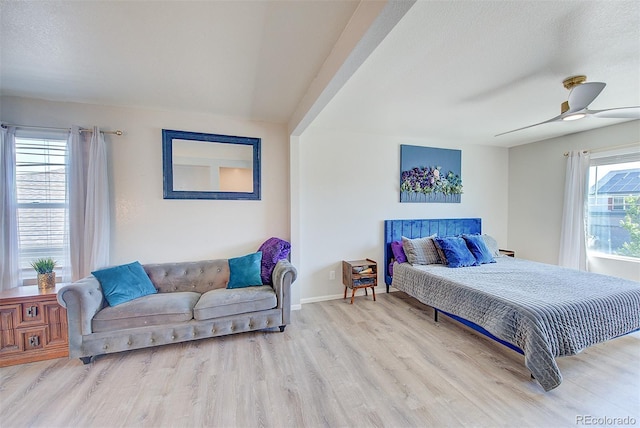 bedroom with a textured ceiling, ceiling fan, and light wood-type flooring