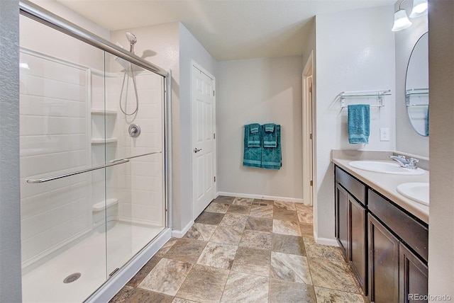 bathroom featuring a shower with door and vanity