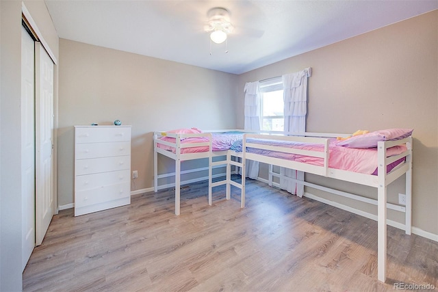 bedroom featuring ceiling fan, light hardwood / wood-style floors, and a closet