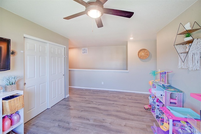 rec room with ceiling fan and light wood-type flooring