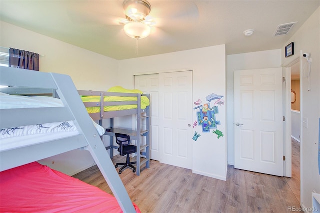 bedroom featuring light wood-type flooring, ceiling fan, and a closet