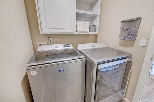 laundry area featuring cabinets and washer and clothes dryer