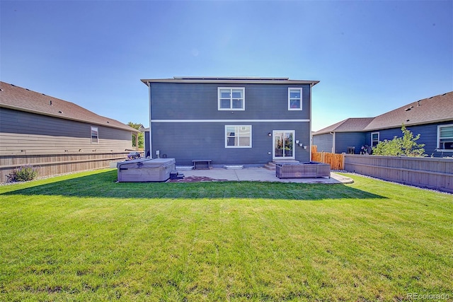 back of house featuring a patio, a yard, and a hot tub