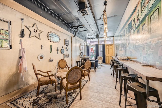 dining space featuring light wood-type flooring, expansive windows, and a workshop area