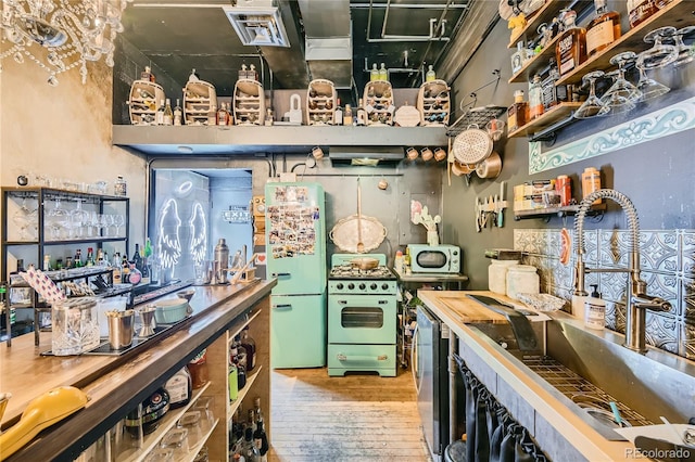 kitchen with wood-type flooring, white appliances, and sink