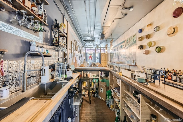 bar with dark hardwood / wood-style flooring and wooden counters