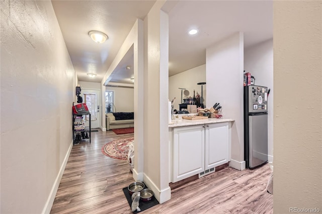 corridor with light hardwood / wood-style flooring