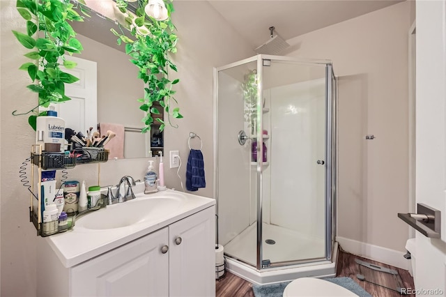 bathroom with hardwood / wood-style floors, vanity, and an enclosed shower