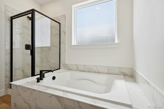 bathroom featuring hardwood / wood-style flooring and separate shower and tub