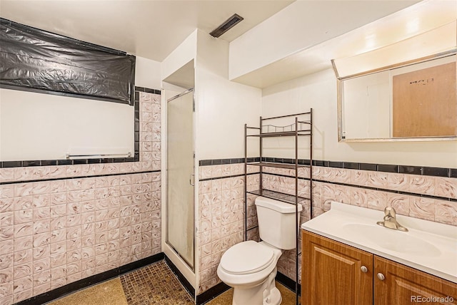 260 Flint Way, Broomfield, CO 80020 - full bathroom with tile walls, toilet, a shower stall, vanity, and a wainscoted wall