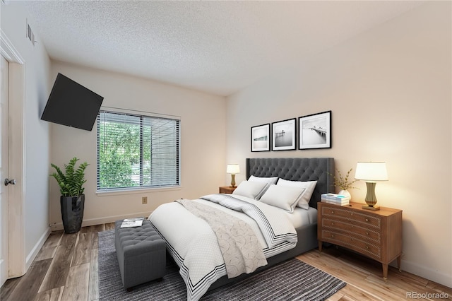 bedroom with hardwood / wood-style flooring and a textured ceiling