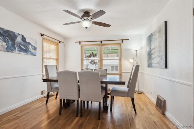 dining space with ceiling fan and light hardwood / wood-style flooring