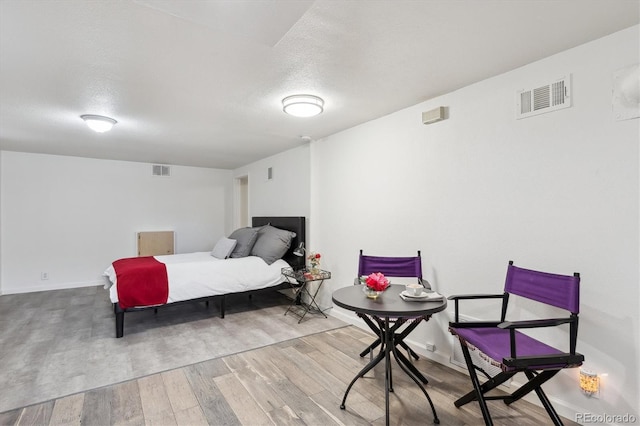 bedroom with hardwood / wood-style floors and a textured ceiling