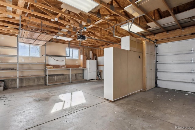 garage with a garage door opener and white fridge