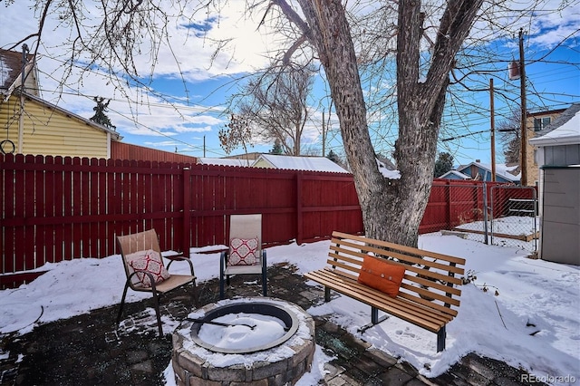 yard layered in snow with an outdoor fire pit