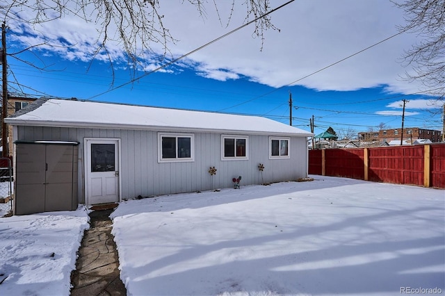 view of snow covered back of property