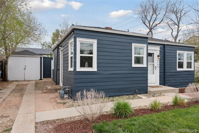 view of front of home featuring a storage shed and an outdoor structure