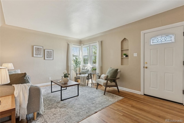 living area with baseboards and light wood-style flooring