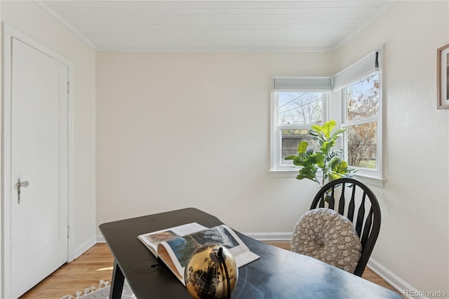 dining area with light wood-style floors, baseboards, and crown molding