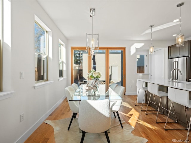 dining space with light wood-type flooring and baseboards