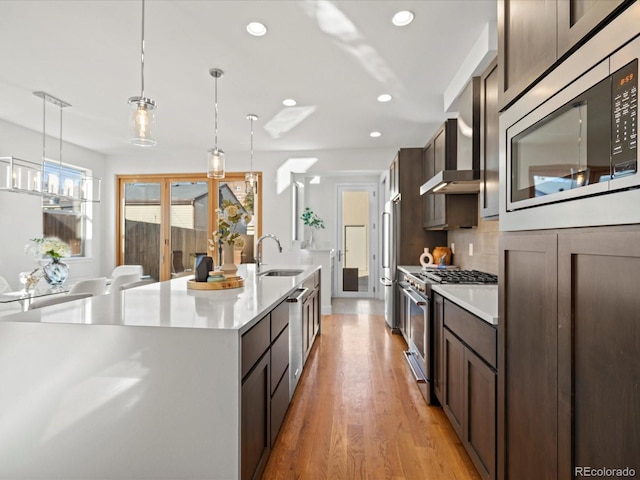 kitchen with stainless steel appliances, light countertops, a sink, and decorative backsplash