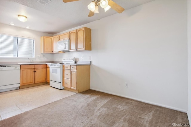 kitchen featuring ceiling fan, white appliances, light brown cabinetry, and light carpet