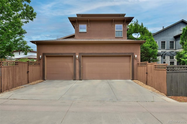 8044 E 24th Ave, Denver, CO 80238 - view of front of property with a gate, stucco siding, and driveway