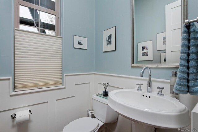 8044 E 24th Ave, Denver, CO 80238 - bathroom featuring a sink, toilet, and a wainscoted wall